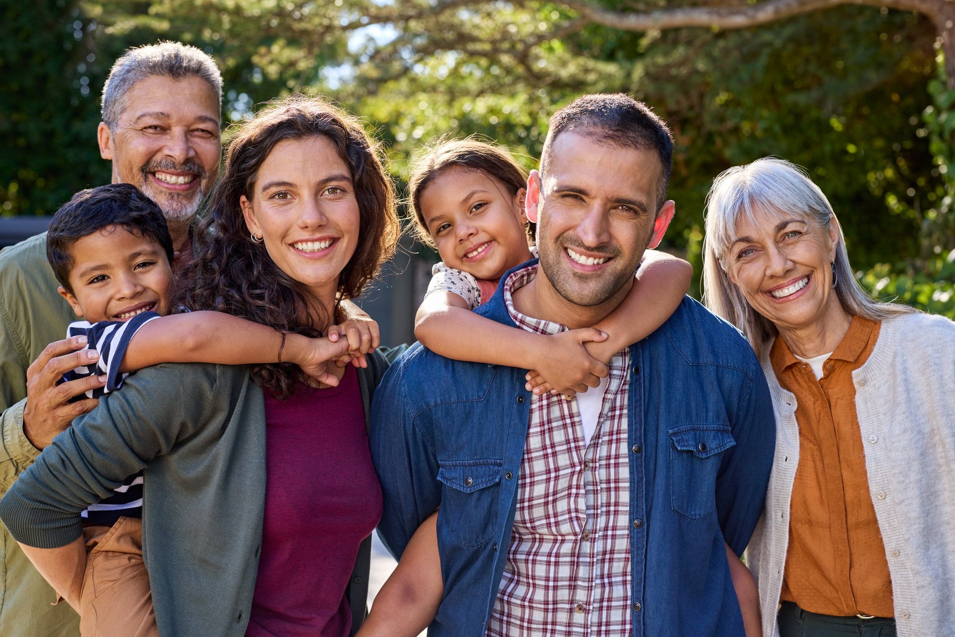 Happy multiethnic family posing together outdoors in a park